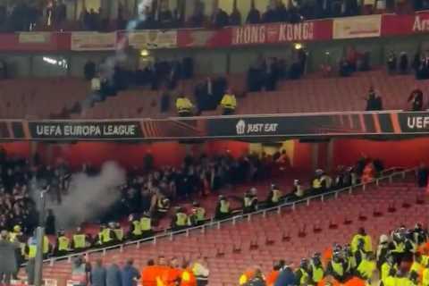 Chaos at end of Arsenal clash with PSV as away fans throw flares into home end and rip out seats as riot cops intervene